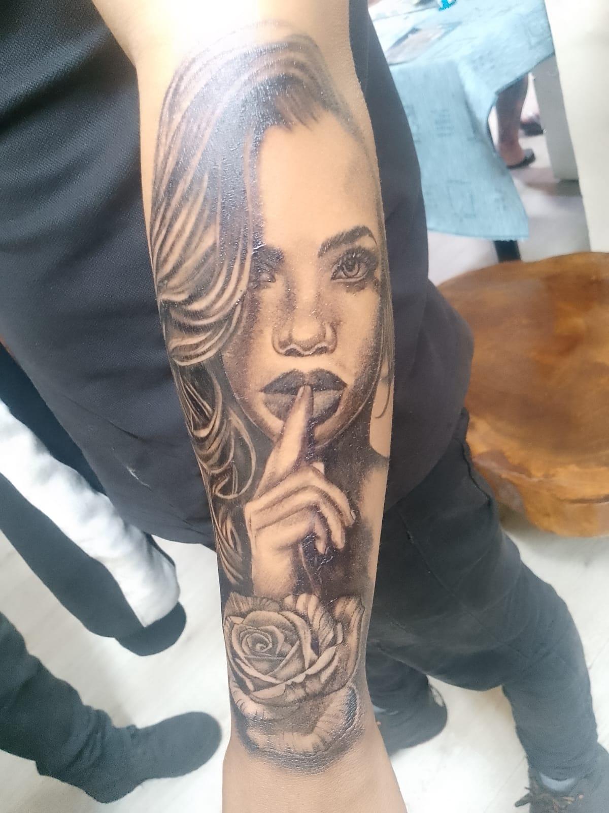 Tatuaje de rosa con gesto de silencio en black and grey realismo
